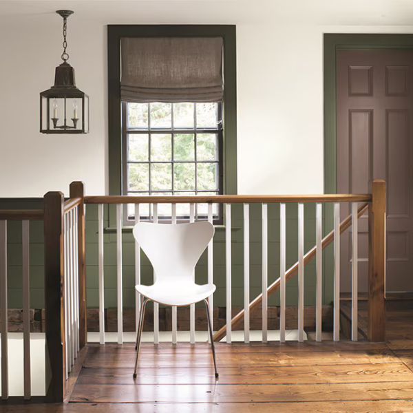 A well-lit open stairway area featuring walls, board-and-batten wainscoting, trim, and a door painted in coordinating Benjamin Moore Williamsburg Color Collection shades